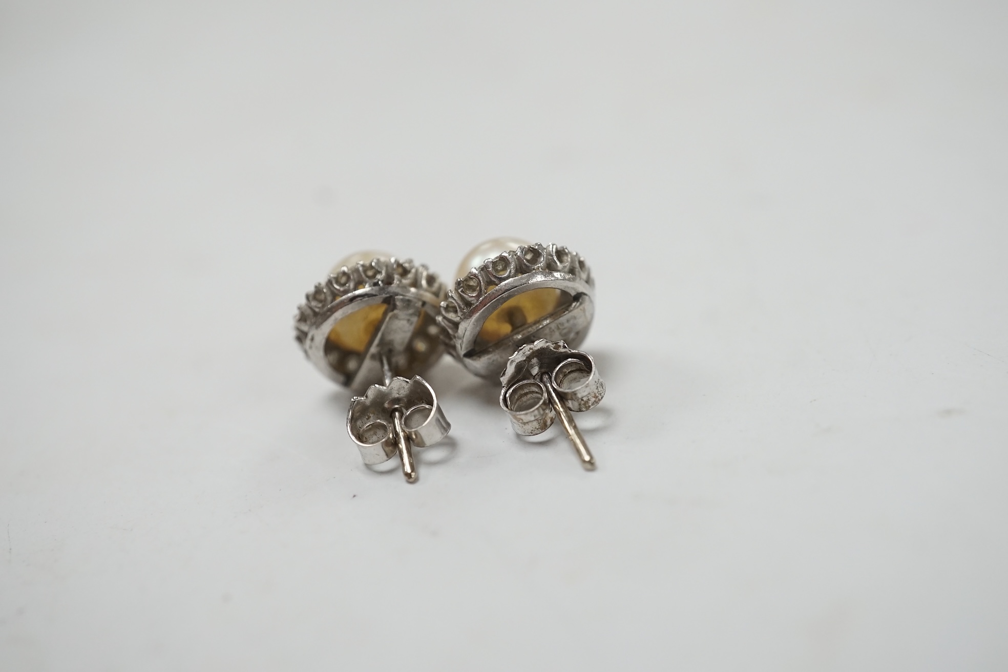 A pair of white metal cultured pearl and diamond cluster set ear studs, 10mm, gross weight 3.6 grams. Condition - fair to good